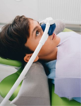 Young boy in the dental chair with a nitrous oxide mask over his nose